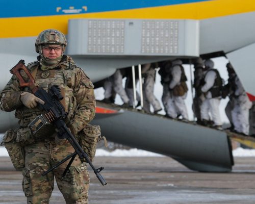 epa07212071 Ukrainian soldier stands guard as paratroopers board a plane during their departure to the Eastern-Ukrainian conflict zone at the military airbase not far of Zhytomyr city, about 130 km from capital Kiev, Ukraine, 06 December 2018. Ukrainian President, Supreme Commander-in-Chief of the Armed Forces of Ukraine Petro Poroshenko on Wednesday addressed the Ukrainian soldiers ahead of Armed Forces Day, which is marked on December 6, noting that for the fifth consecutive year the military celebrate their professional holiday on the frontline of the Russian-Ukrainian war.  EPA/SERGEY DOLZHENKO